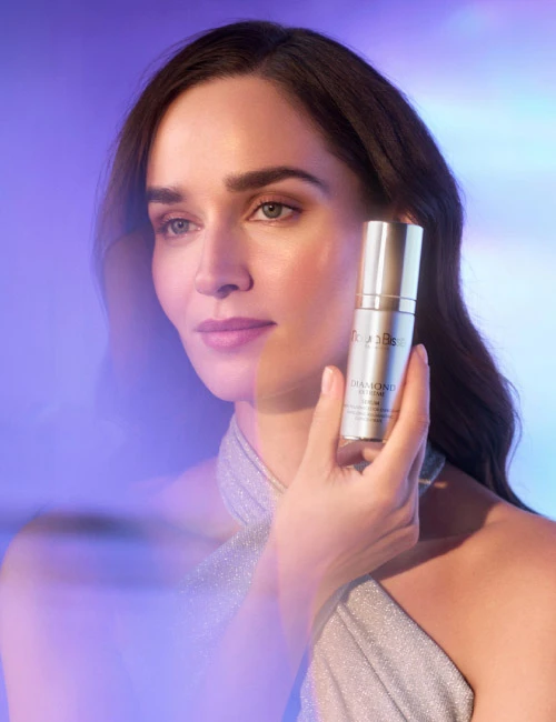 Diamond Extreme Serum ibeing held by a model. She's wearing a gown and looking at the horizon.