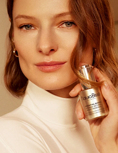 Smiling woman holding Stabilizing Purifying Concentrate in front of her face.