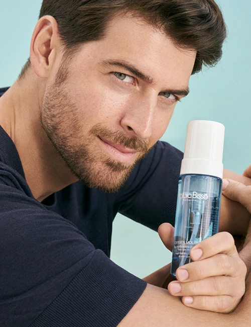 Man with dark hair and blue eyes in his late thirties holding Oxyen Mousse. Product featured in bestsellers page.